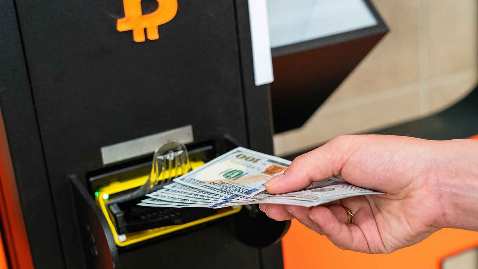Man at Bitcoin ATM exchanging cash for Bitcoin