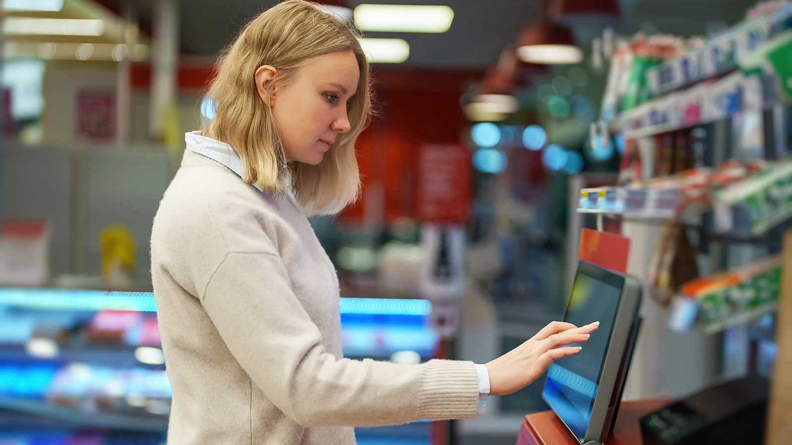 Woman in gas station converting cash into Bitcoin at a CoinMover Bitcoin ATM